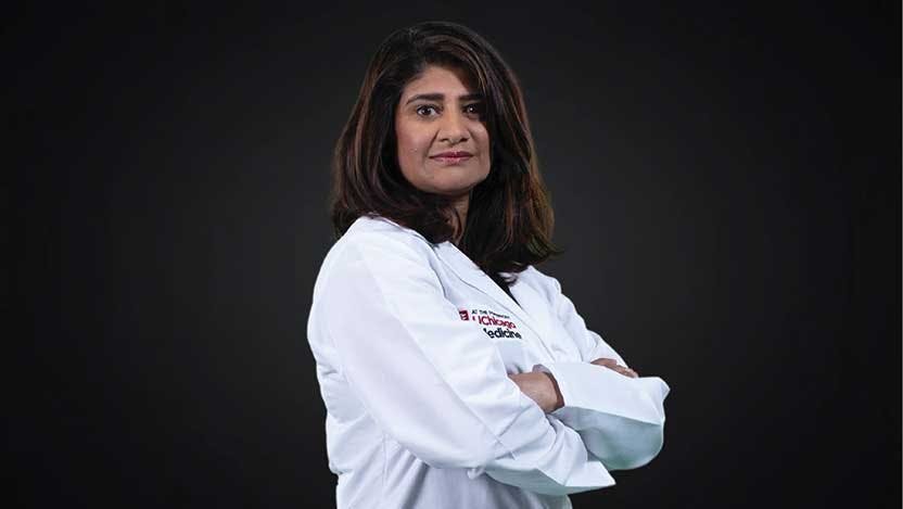 Medical oncologist Sonali Smith, MD, facing the camera with crossed arms against a black background