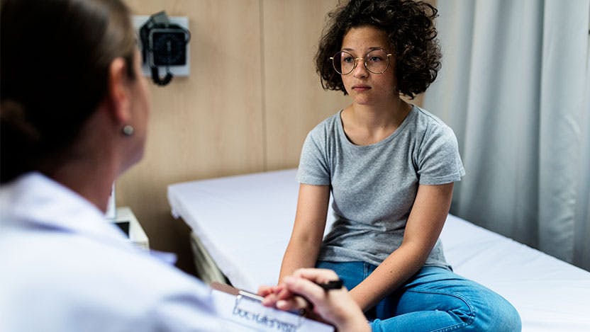 Young lupus patient talks with pediatric rheumatologist