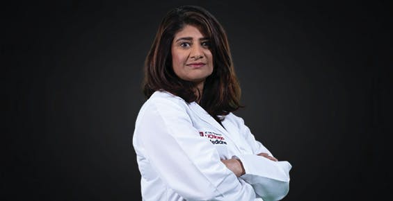 Dr. Sonali Smith in a white coat with her arms crossed facing the camera