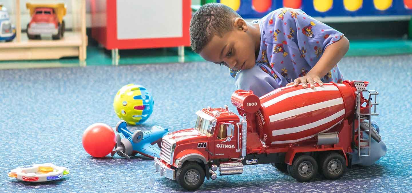 Pediatric hospital patient playing with a truck in the playroom